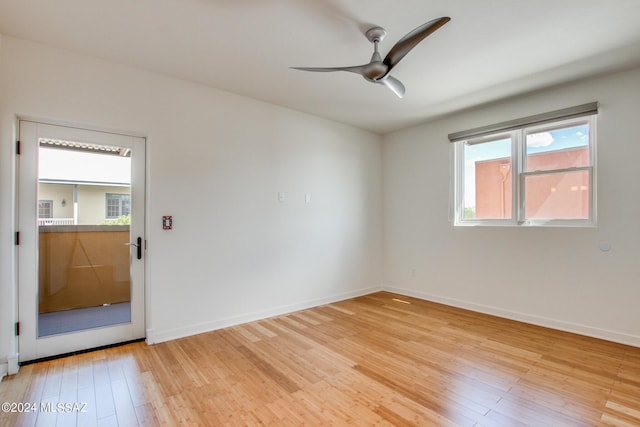 empty room with ceiling fan and light hardwood / wood-style flooring