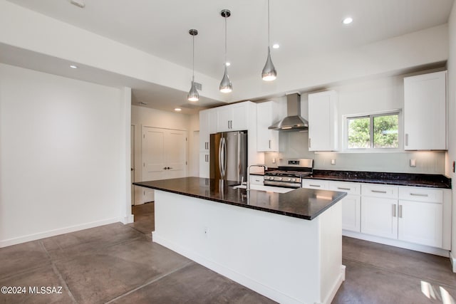 kitchen with pendant lighting, a kitchen island with sink, wall chimney exhaust hood, appliances with stainless steel finishes, and white cabinetry