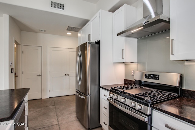 kitchen featuring white cabinets, appliances with stainless steel finishes, concrete flooring, and wall chimney exhaust hood