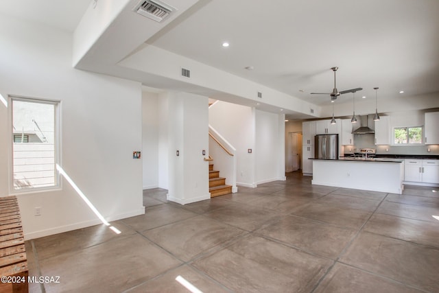 unfurnished living room featuring concrete flooring and ceiling fan