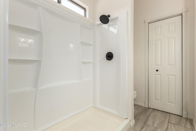 bathroom featuring a shower and toilet