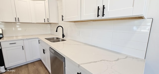 kitchen with decorative backsplash, white cabinets, light stone counters, sink, and dishwasher