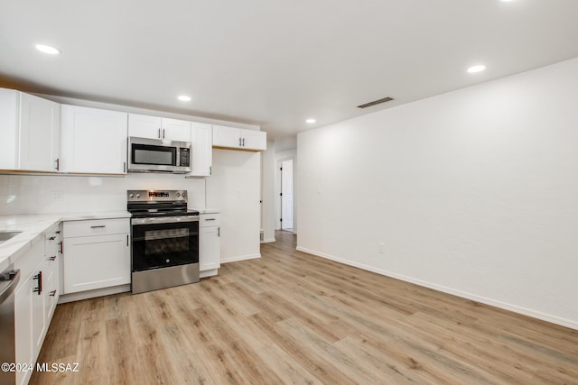 kitchen with white cabinetry, light hardwood / wood-style flooring, and appliances with stainless steel finishes