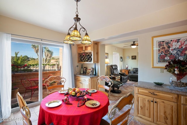 dining space with ceiling fan with notable chandelier and light tile patterned floors