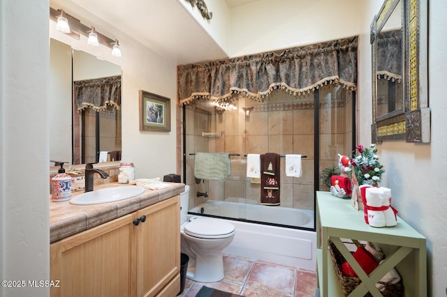 full bathroom featuring vanity, shower / bath combination with glass door, tile patterned floors, and toilet