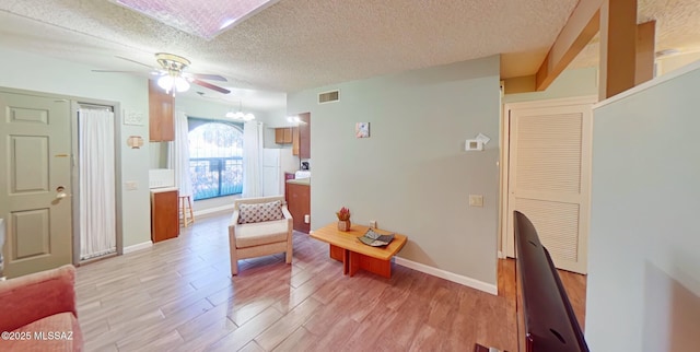 living area featuring ceiling fan, a textured ceiling, and light hardwood / wood-style flooring