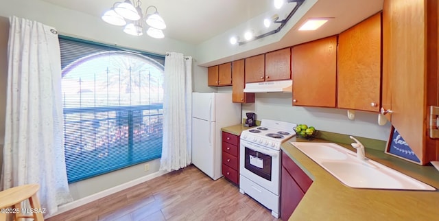 kitchen with pendant lighting, white appliances, sink, and an inviting chandelier