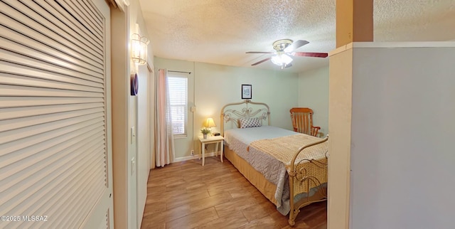 bedroom featuring ceiling fan, a textured ceiling, and light wood-type flooring