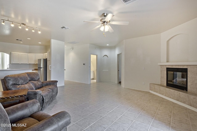 living room with ceiling fan, sink, a high end fireplace, and light tile patterned floors