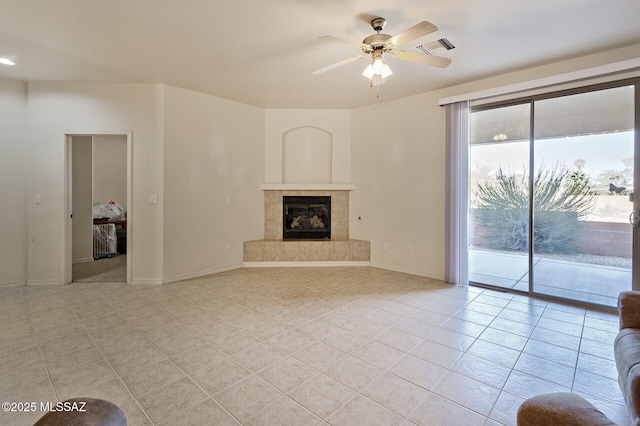 unfurnished living room featuring ceiling fan, light tile patterned floors, and a tile fireplace