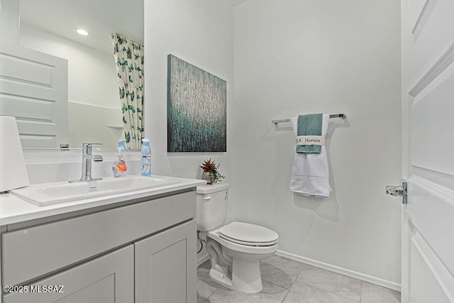 bathroom featuring tile patterned flooring, vanity, and toilet