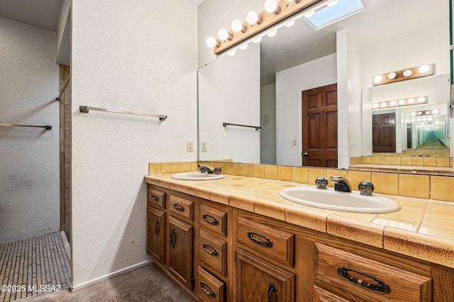 bathroom featuring vanity, backsplash, a skylight, and walk in shower