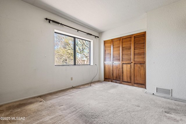 unfurnished bedroom with carpet flooring and a closet