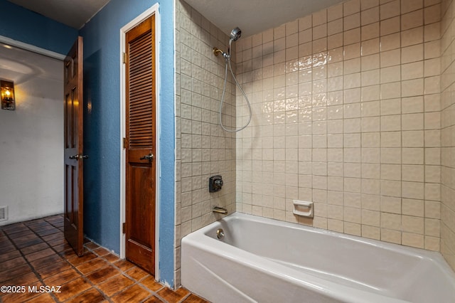 bathroom with tile patterned floors and tiled shower / bath