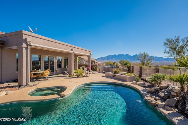 view of pool with a patio, an in ground hot tub, and a mountain view