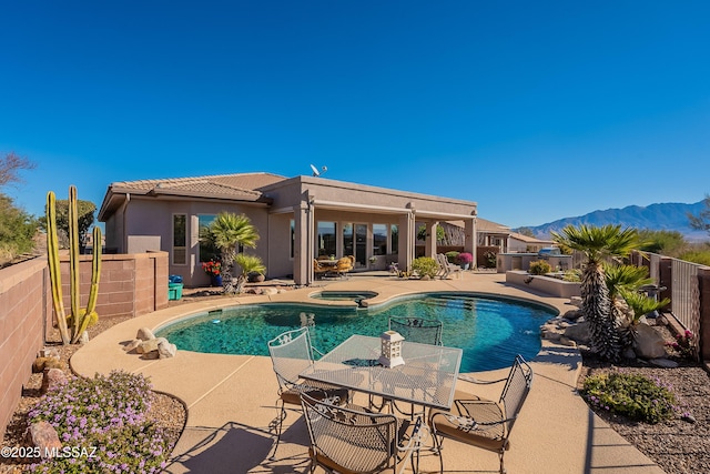 view of swimming pool with a patio, an in ground hot tub, and a mountain view