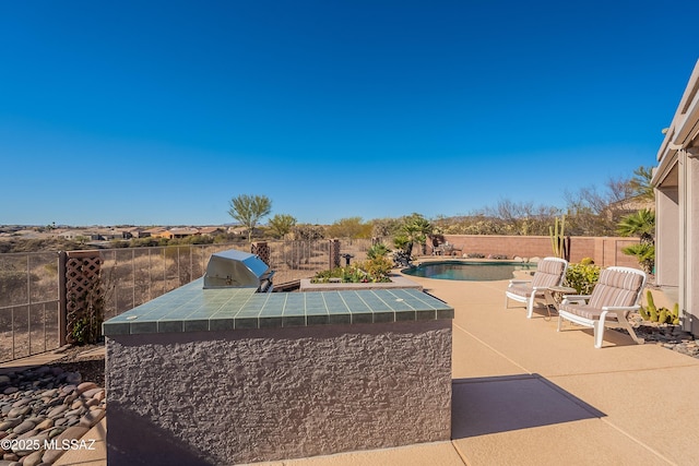 view of swimming pool featuring a patio, area for grilling, and exterior kitchen