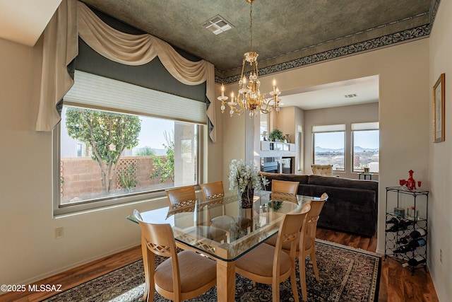 dining room with a mountain view, a notable chandelier, and dark hardwood / wood-style floors