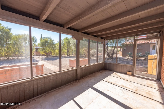 unfurnished sunroom featuring beam ceiling