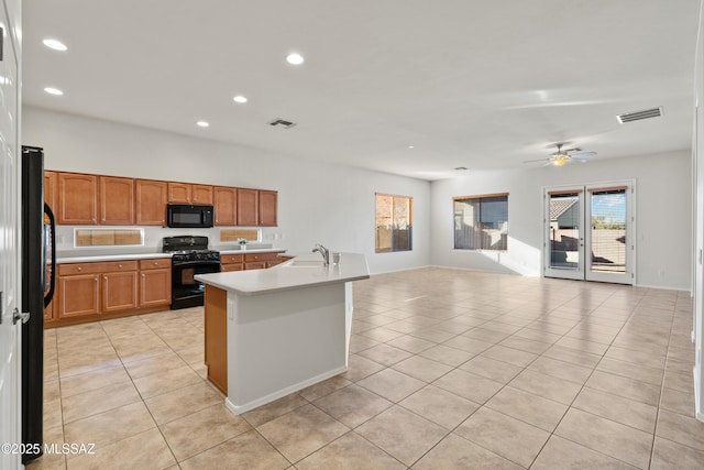 kitchen featuring black appliances, a center island with sink, sink, ceiling fan, and light tile patterned floors