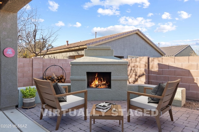 7826 W Sage Creek Ct, Tucson, AZ 85743 - view of patio / terrace featuring a warm lit fireplace and fence