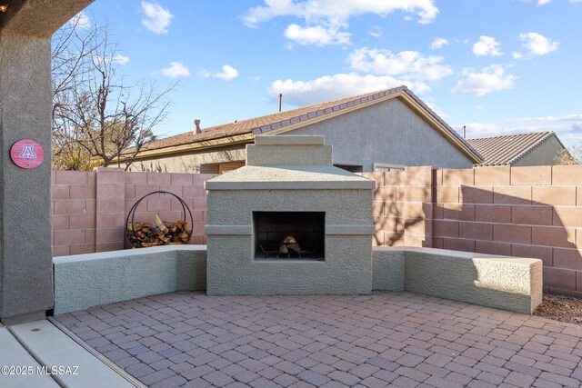 7826 W Sage Creek Ct, Tucson, AZ 85743 - view of patio / terrace featuring exterior fireplace and fence