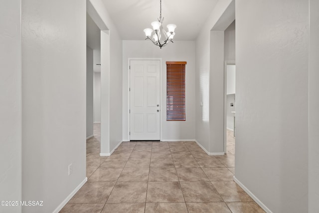 tiled foyer featuring a notable chandelier