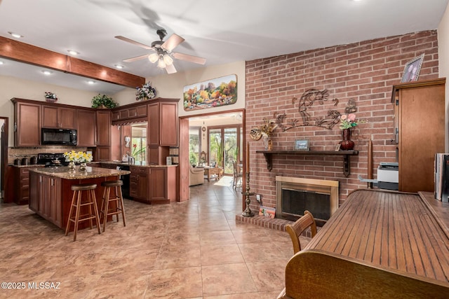 kitchen featuring range, stone countertops, a kitchen breakfast bar, a fireplace, and a kitchen island