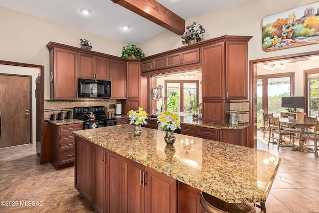 kitchen featuring black appliances, light stone countertops, vaulted ceiling with beams, a breakfast bar area, and decorative backsplash