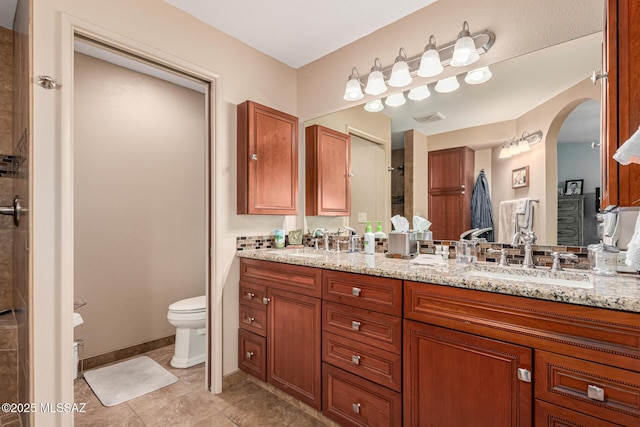 full bathroom with a sink, toilet, double vanity, and visible vents