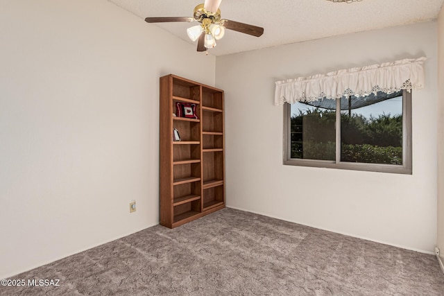 empty room with a textured ceiling, carpet flooring, and ceiling fan