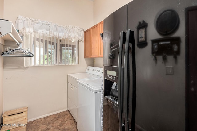 laundry area featuring baseboards, cabinet space, and washer and clothes dryer