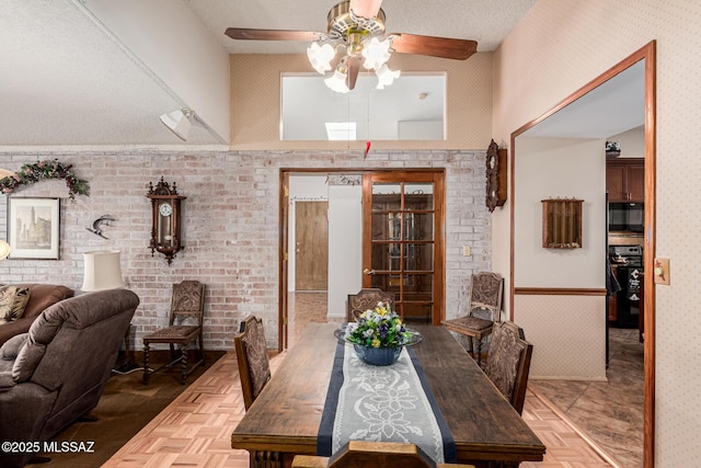 dining room with ceiling fan and wallpapered walls