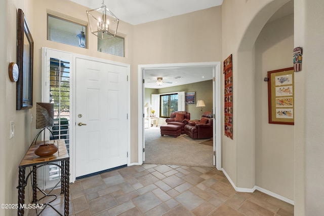 carpeted entrance foyer featuring an inviting chandelier