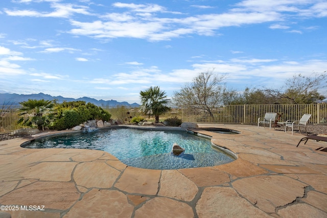 view of pool featuring a mountain view, a patio, pool water feature, and an in ground hot tub