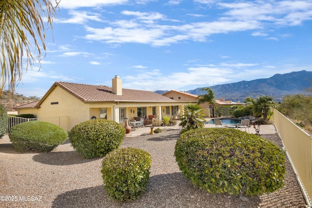 view of front of house with a mountain view, a patio, and a fenced in pool