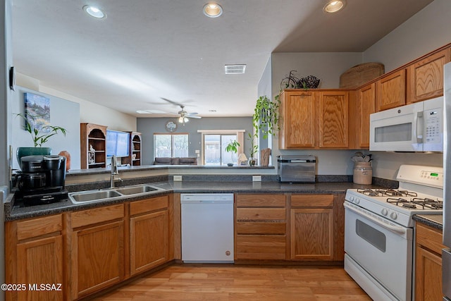 kitchen featuring white appliances, sink, ceiling fan, light hardwood / wood-style floors, and kitchen peninsula