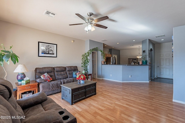 living room featuring ceiling fan and light wood-type flooring