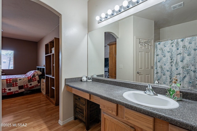 bathroom with vanity, a shower with shower curtain, and hardwood / wood-style flooring