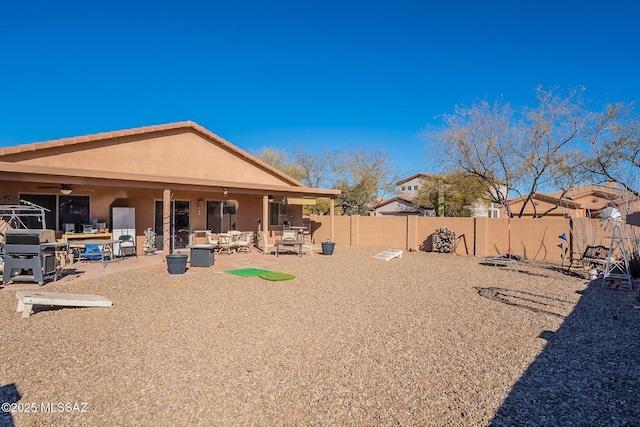 back of property featuring ceiling fan and a patio