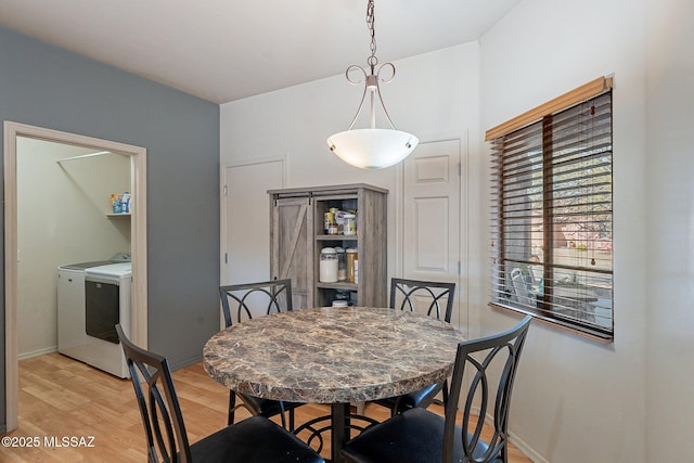 dining space featuring washer and clothes dryer and light hardwood / wood-style flooring