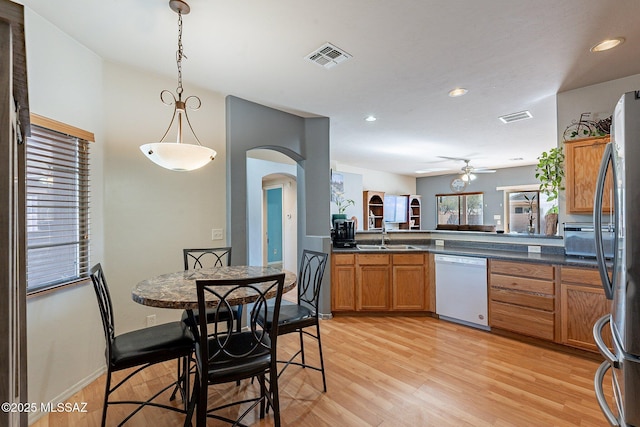 kitchen with ceiling fan, dishwasher, stainless steel fridge, light hardwood / wood-style floors, and decorative light fixtures