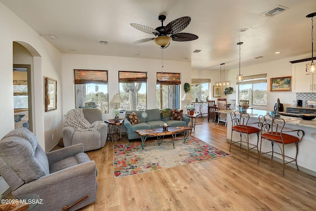 living room with light hardwood / wood-style floors and ceiling fan