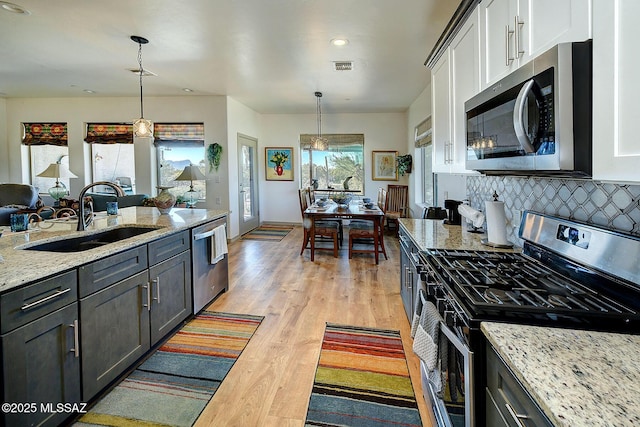 kitchen with white cabinets, pendant lighting, appliances with stainless steel finishes, and sink