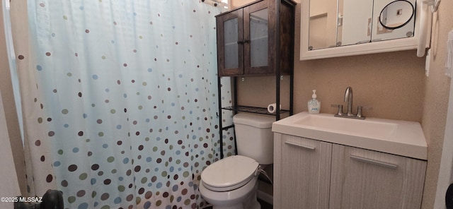 bathroom with curtained shower, vanity, and toilet