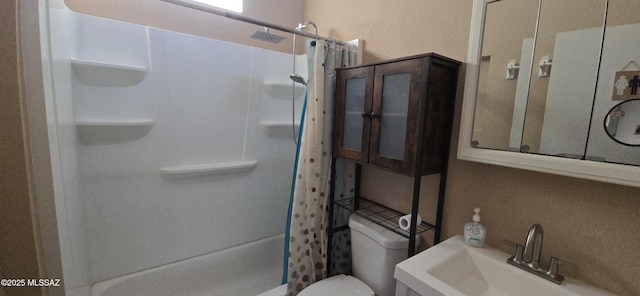 bathroom with toilet, curtained shower, and sink