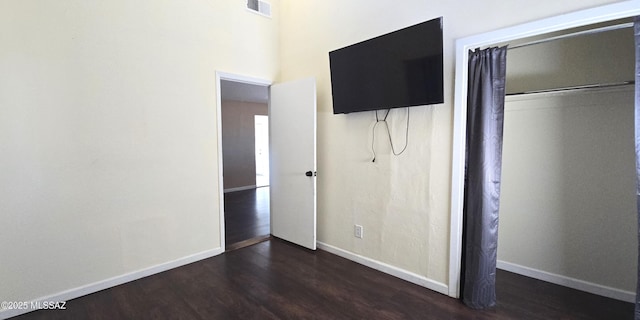 unfurnished bedroom featuring dark hardwood / wood-style floors and a closet