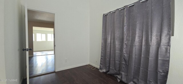 unfurnished room featuring dark wood-type flooring