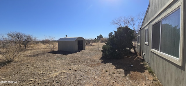 view of yard featuring a rural view and a storage unit