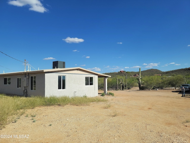 rear view of property with a mountain view and central air condition unit